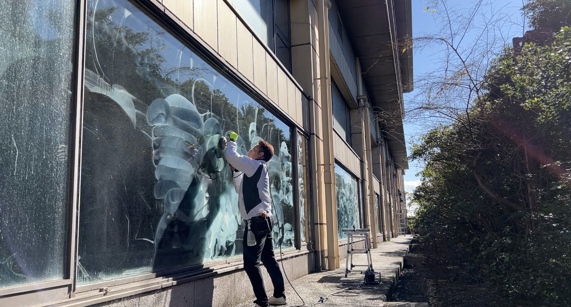 GTOSの作業者が建物の大型ガラスを施工している風景